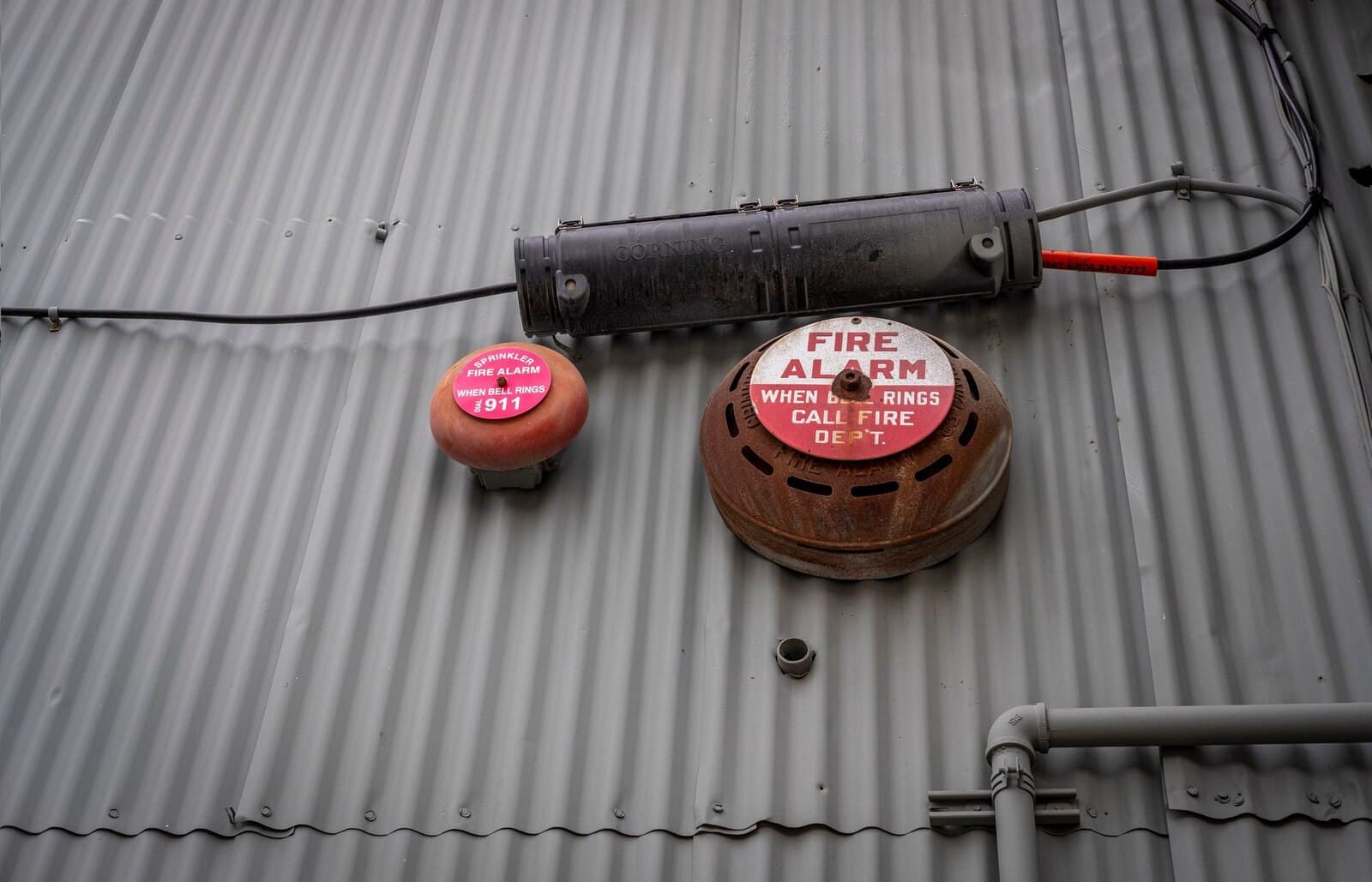 Industrial fire alarm bell and notification equipment mounted on a metal wall