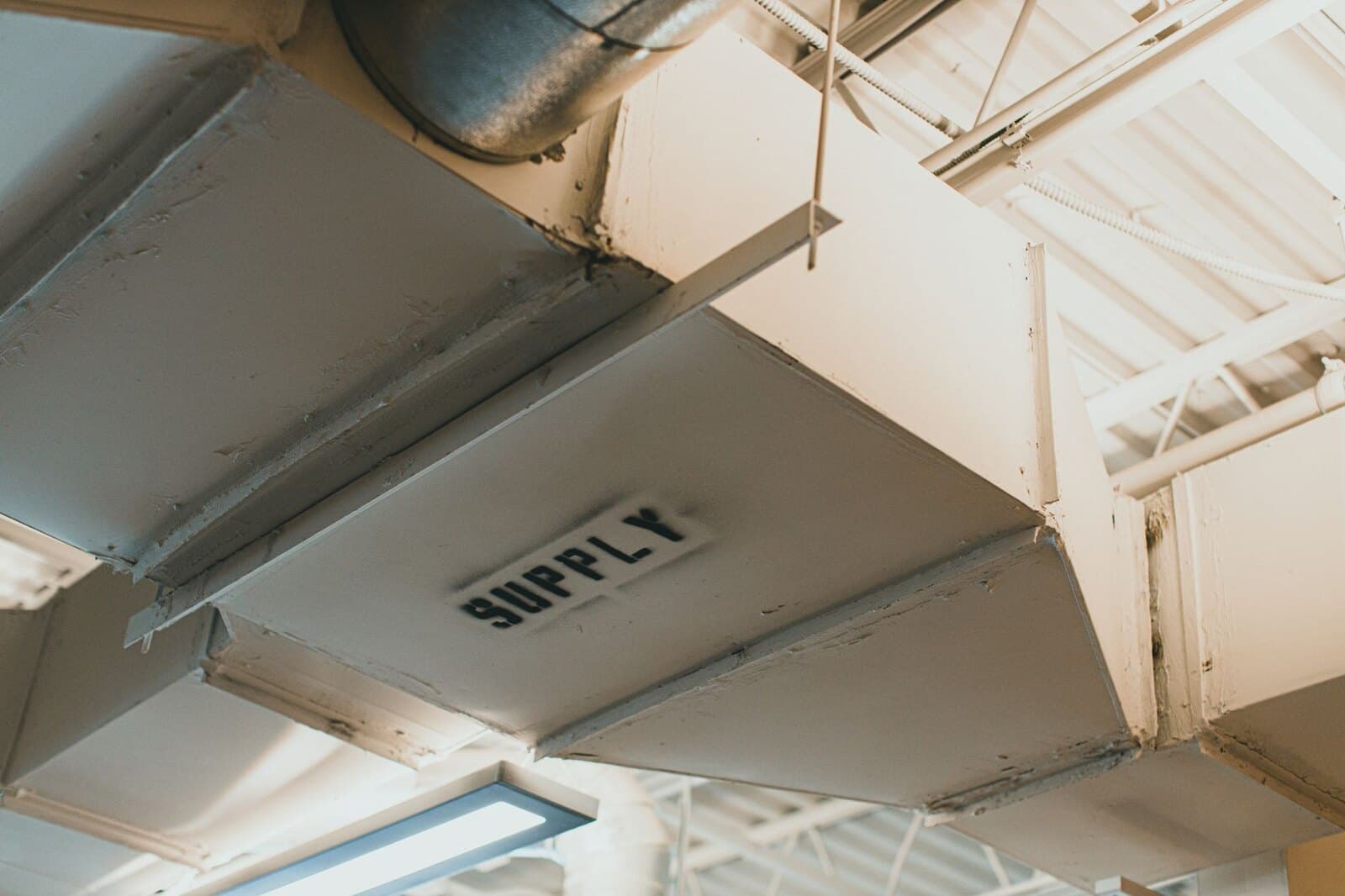 Industrial supply air duct installed beneath a commercial ceiling