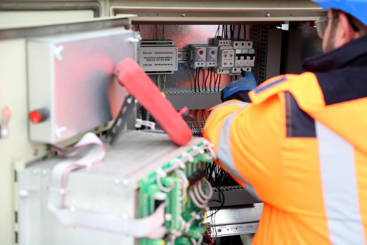 Engineer inspecting an industrial electrical circuit board