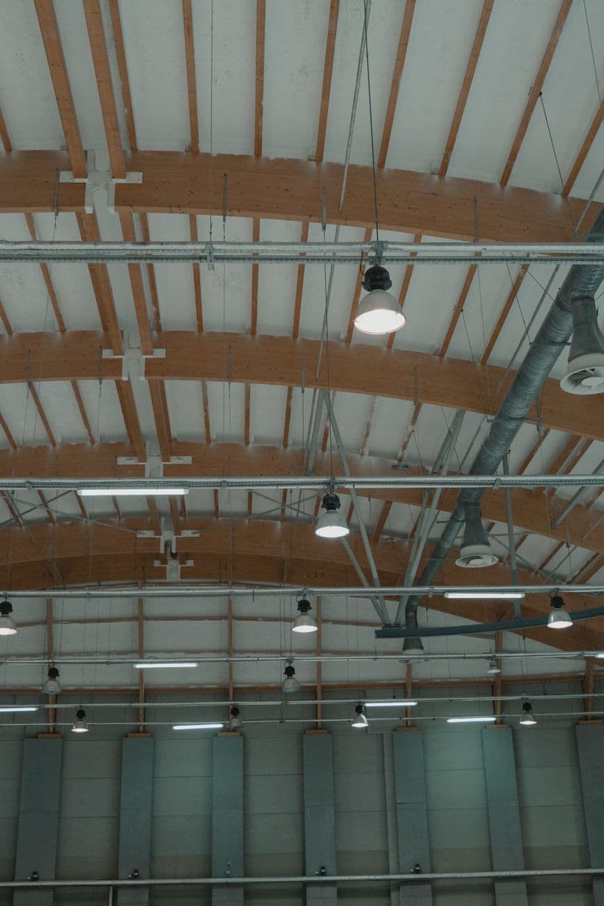 Industrial warehouse ceiling with rows of commercial light fixtures
