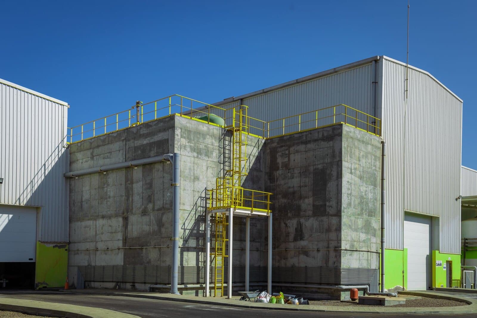 Modern industrial warehouse exterior with concrete facade and yellow railings
